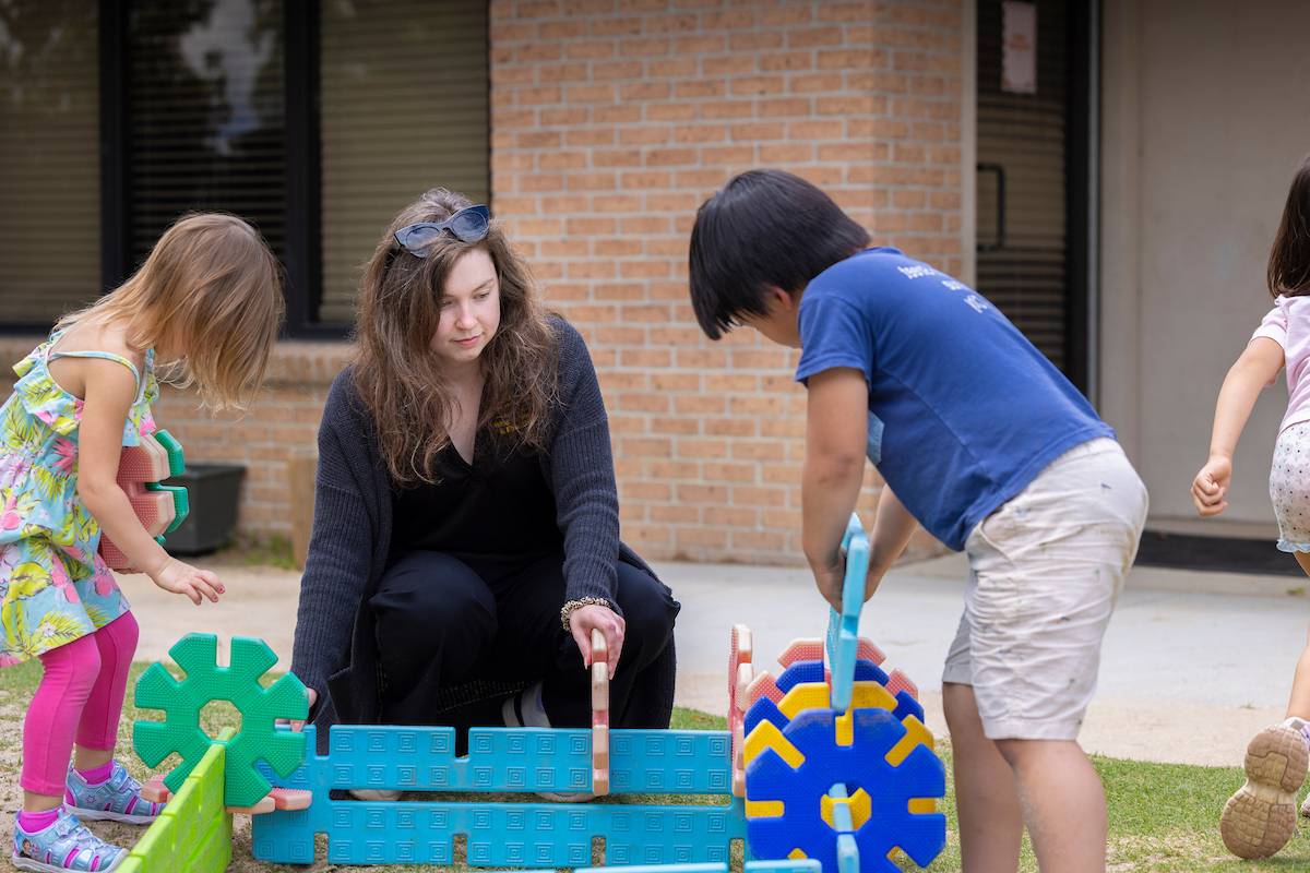 LSU Preschool students play outside with a teacher LSU Preschool students play outside with a teacher