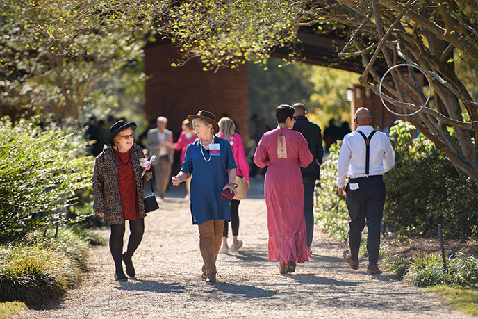 group of people walk through gardens